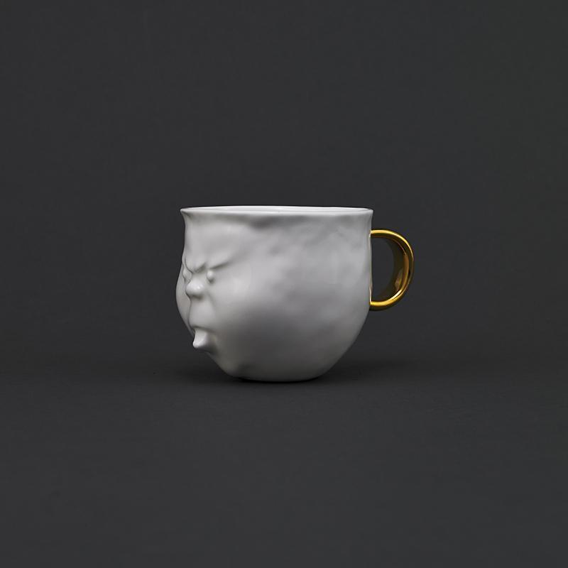 產品特色 杯身造型為藝術家瞿廣慈手工捏製，每一處凹凸與曲折都匠心獨運，是藝術家對於生活的理解 選用骨粉含量為46%以上的優質骨瓷 通過1300度高溫手工燒製而成，杯體潔白如遇，質地通透，輕擊則清脆悅耳