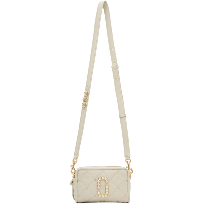 灰色单肩包，采用粒面皮革面料绗缝设计，饰有珍珠铆钉。可拆卸、可调节式龙虾扣肩带附有 D 形环五金，正面珍珠徽标牌，背面贴袋和金色徽标压花。主隔层拉链开合，驼色布面衬里，内附贴袋和徽标皮牌。金色徽标雕花