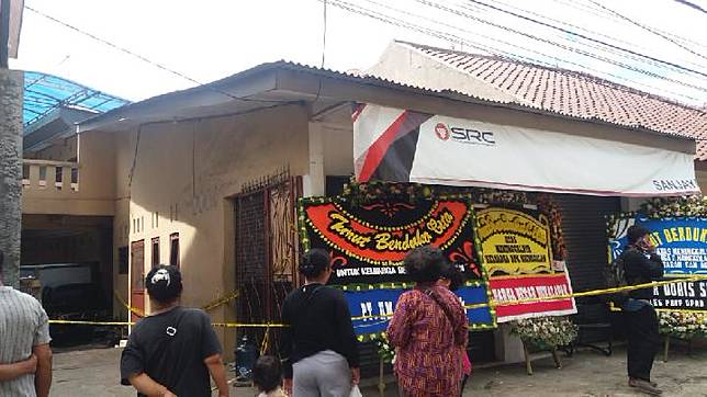 Warga melihat tiga karangan bunga tampak di depan rumah korban pembunuhan satu keluarga di Bekasi, Rabu, 14 November 2018 TEMPO/Adi Warsono
