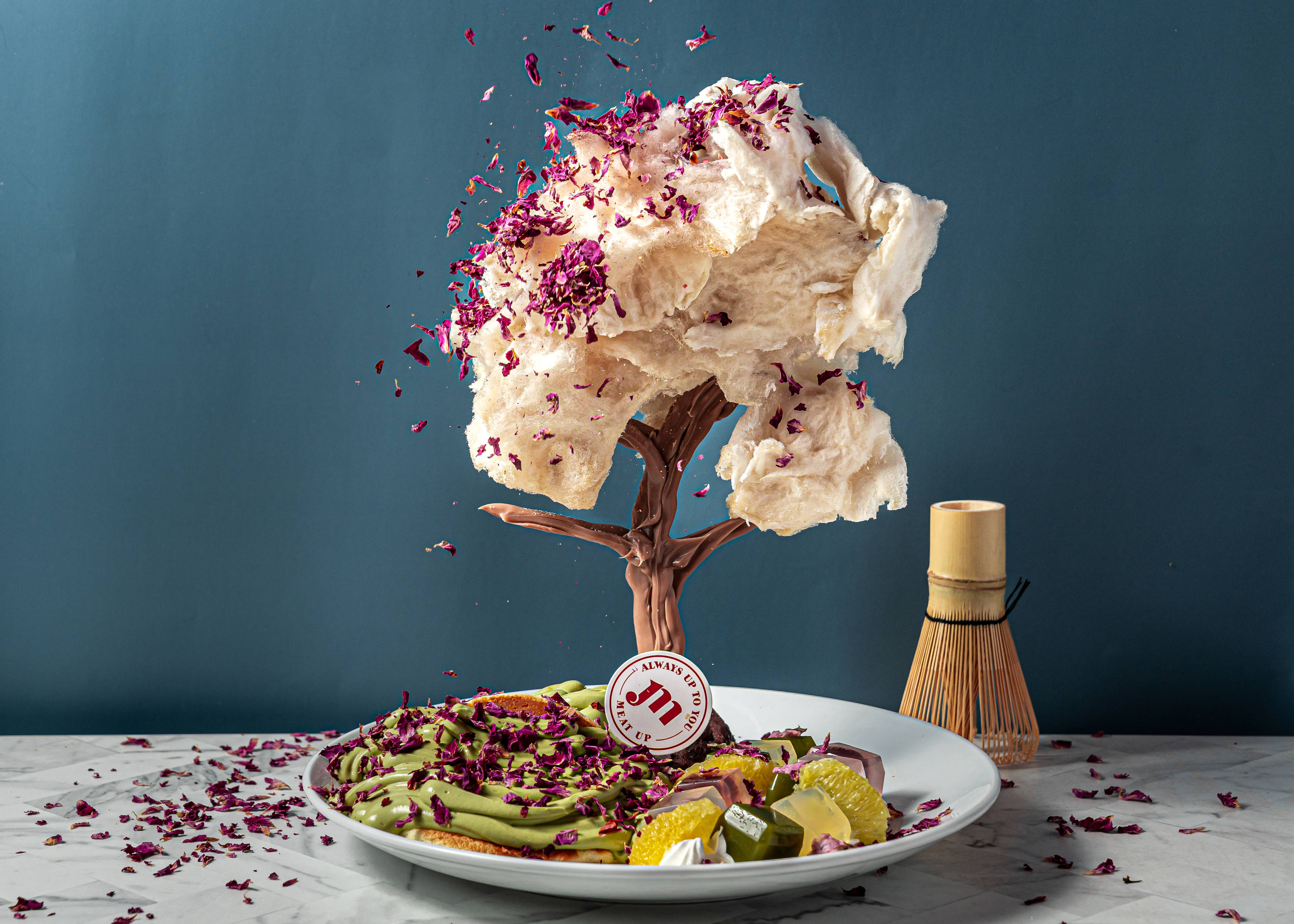 如同微型展覽的甜點，「日本賞櫻」以巧克力製作成樹幹、蓬鬆棉花糖作為櫻花，櫻花樹下則是擺上鬆軟綿密的舒芙蕾，形成一幅別具詩意可以品嚐的美景。（圖片提供/ Meat Up）