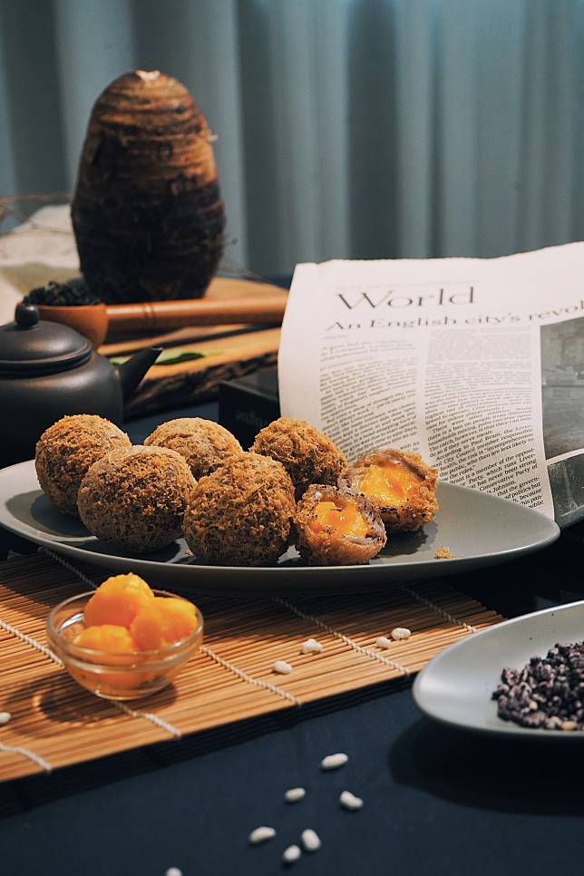 獨家招牌手作流沙芋泥球。以大甲芋頭泥包裹金黃流沙餡，另選用古早味米香舖底盛盤，一口芋泥球搭配一口米香，香濃流沙伴隨米香酥脆口感，鹹甜滋味每桌必點。(圖/ hechino做茶菜-大墩店)