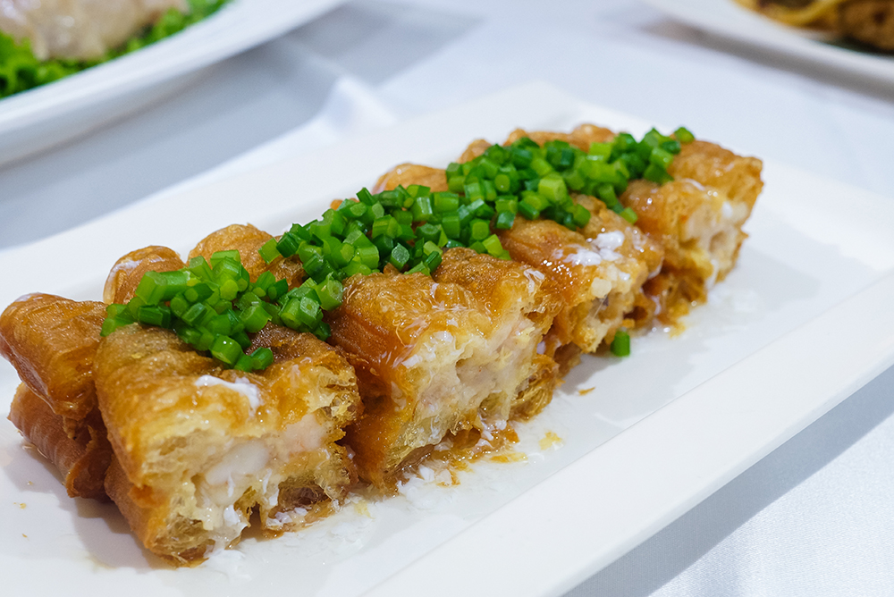 「翠玉百花鑲油條」油條內鑲有臺南特有的火燒蝦漿，咬下時能同時嚐到油條的酥脆與蝦漿的Q彈口感，令人無比驚艷。(圖片提供/牡丹園 台灣經典料理)