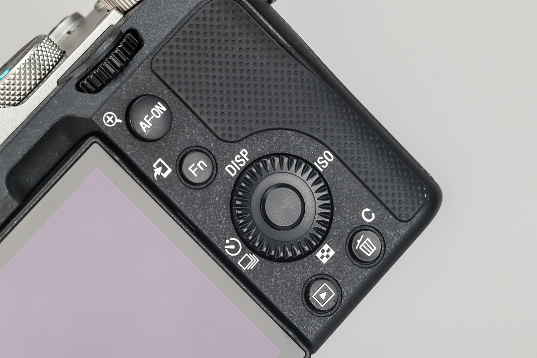 拇指操作區縮小並取消了對焦搖桿，並將 AF-ON 鈕下移取代之。
