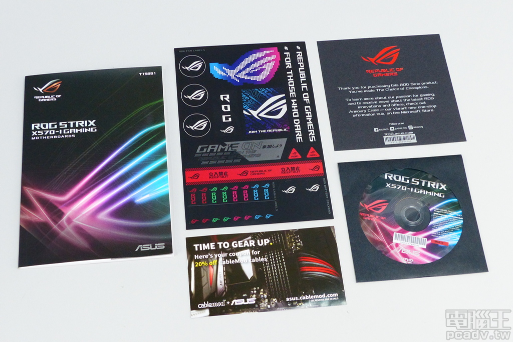 ROG Strix X570-I Gaming 盒裝紙質平面配件一覽，包含說明書、貼紙、ROG 玩家共和國感謝函、CableMod 8 折優惠券、驅動程式與公用程式光碟。