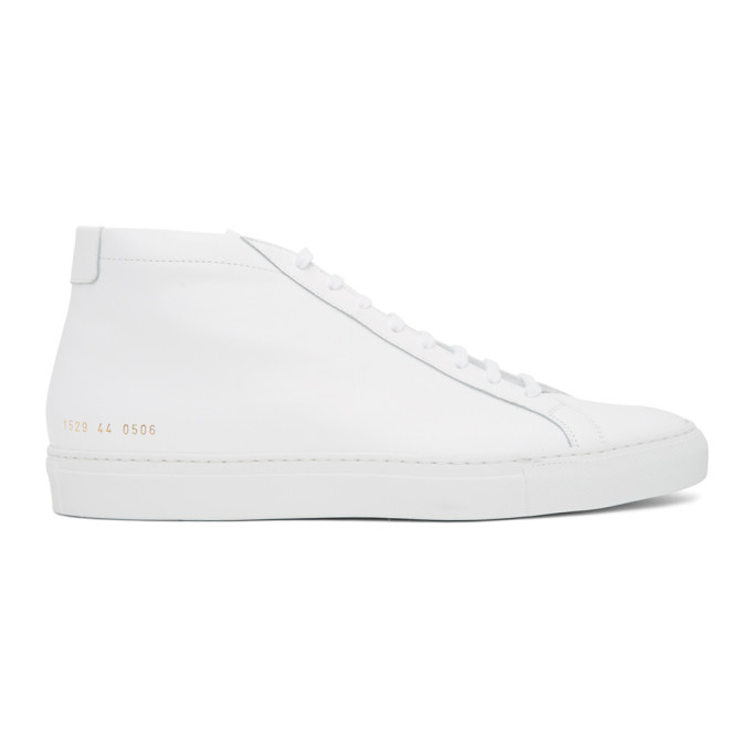 Mid-top buffed leather sneakers in white. Round toe. Tonal lace-up closure. Padded tongue and collar