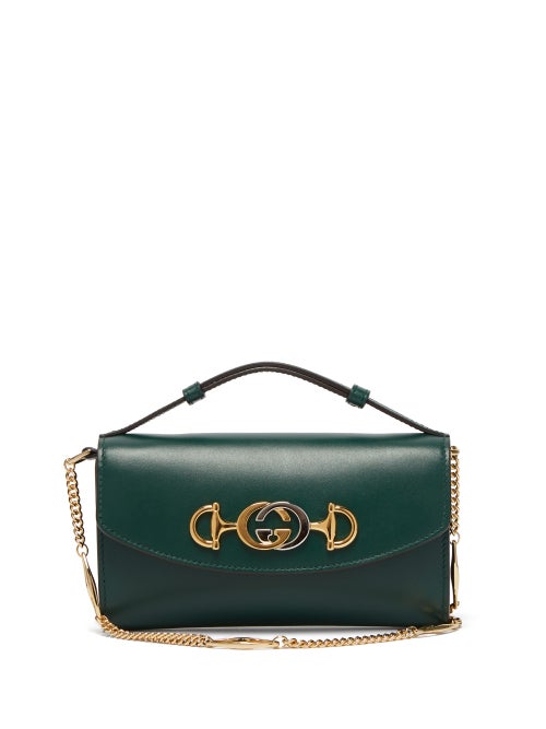 Gucci - Alessandro Michele entwines Gucci's iconic GG and Horsebit motifs to create the silver and gold-tone metal logo plaque of this green Zumi cross-body bag. Crafted in Italy from smooth leather with black lacquered edges, it has a detachable Marina chain-link strap and a magnetic flap closure that opens to reveal a deceptively capacious burgundy interior. Team it with retro-tinged separates for a directional weekday look.