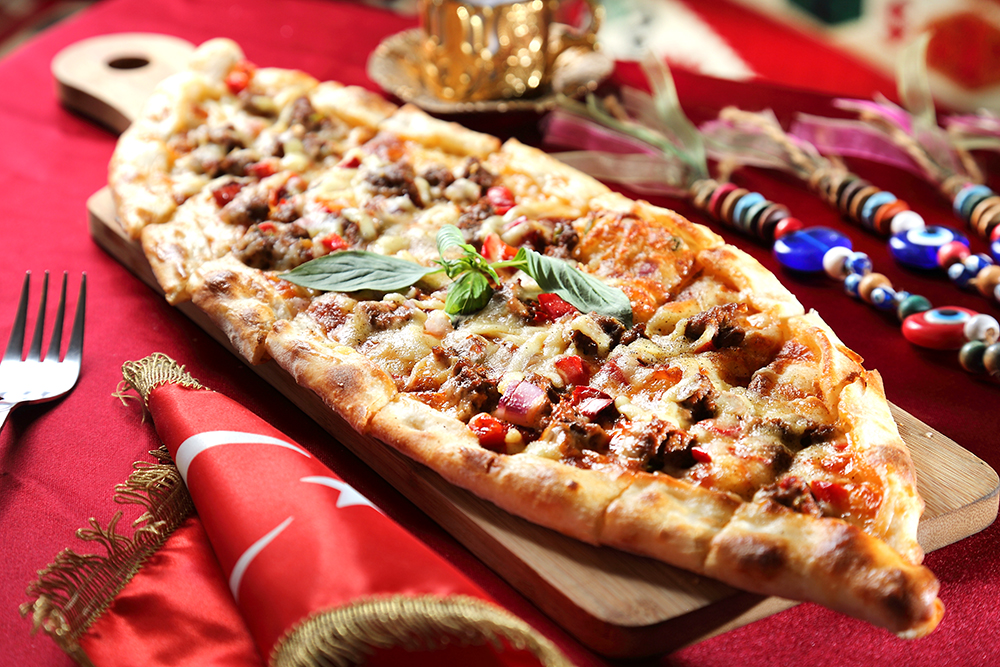 「起司牛肉比嗲」為土耳其版披薩，一入口即感受強烈的香料衝擊，餅皮越嚼越香，邪惡的牽絲起司讓人無法拒絕。(攝影/Carter)