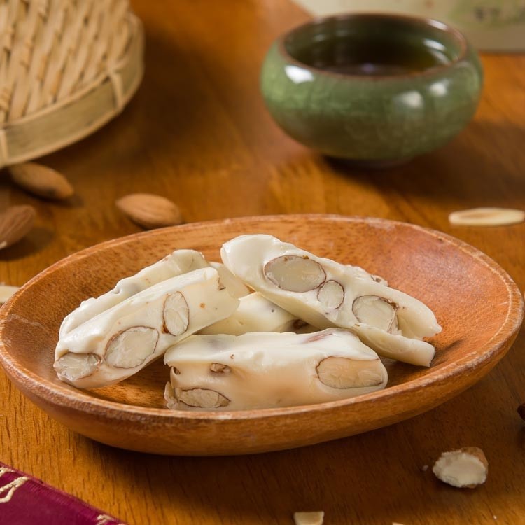 使用高級進口奶粉與奶油，嚴選杏仁及真正的蛋白製成，手工新鮮現做，添加海藻糖，甜而不膩不黏牙，大人小孩都喜愛，不含色素、香料及防腐劑的天然原味零嘴,，送禮首選!【產品規格】品名：純手工 - 杏仁牛軋糖 