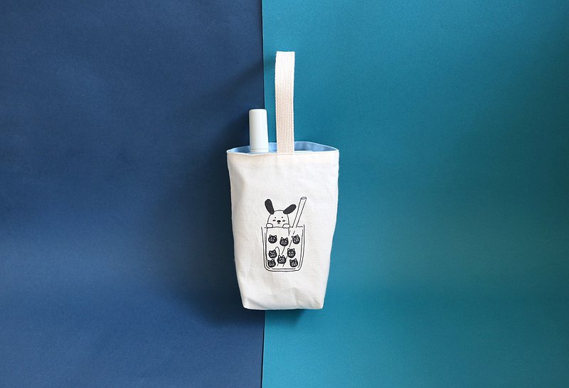 年紀一把還沒戒奶的我 看到手搖就想買 所以出門一定要帶著躲躲狗飲料提袋出門 大小適用所有手搖飲料 冰壩杯 大象杯也都很適合喲 躲躲狗背面是藍色的