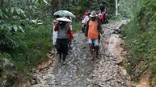Seorang ibu pasca-melahirkan ditandu warga melewati jalan rusak