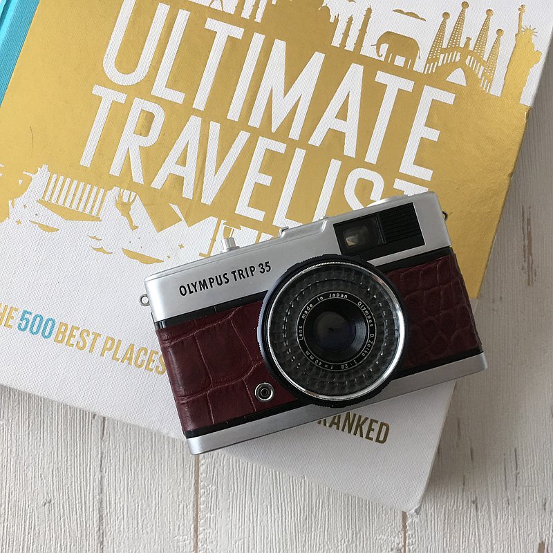 奧林巴斯TRIP35是50多年前日本製造的機械式膠片相機。 我把它維護得很好，並/併讓它可以使用暸/瞭。 身上的部分用真皮重裝，重塑成可愛的人物形象。