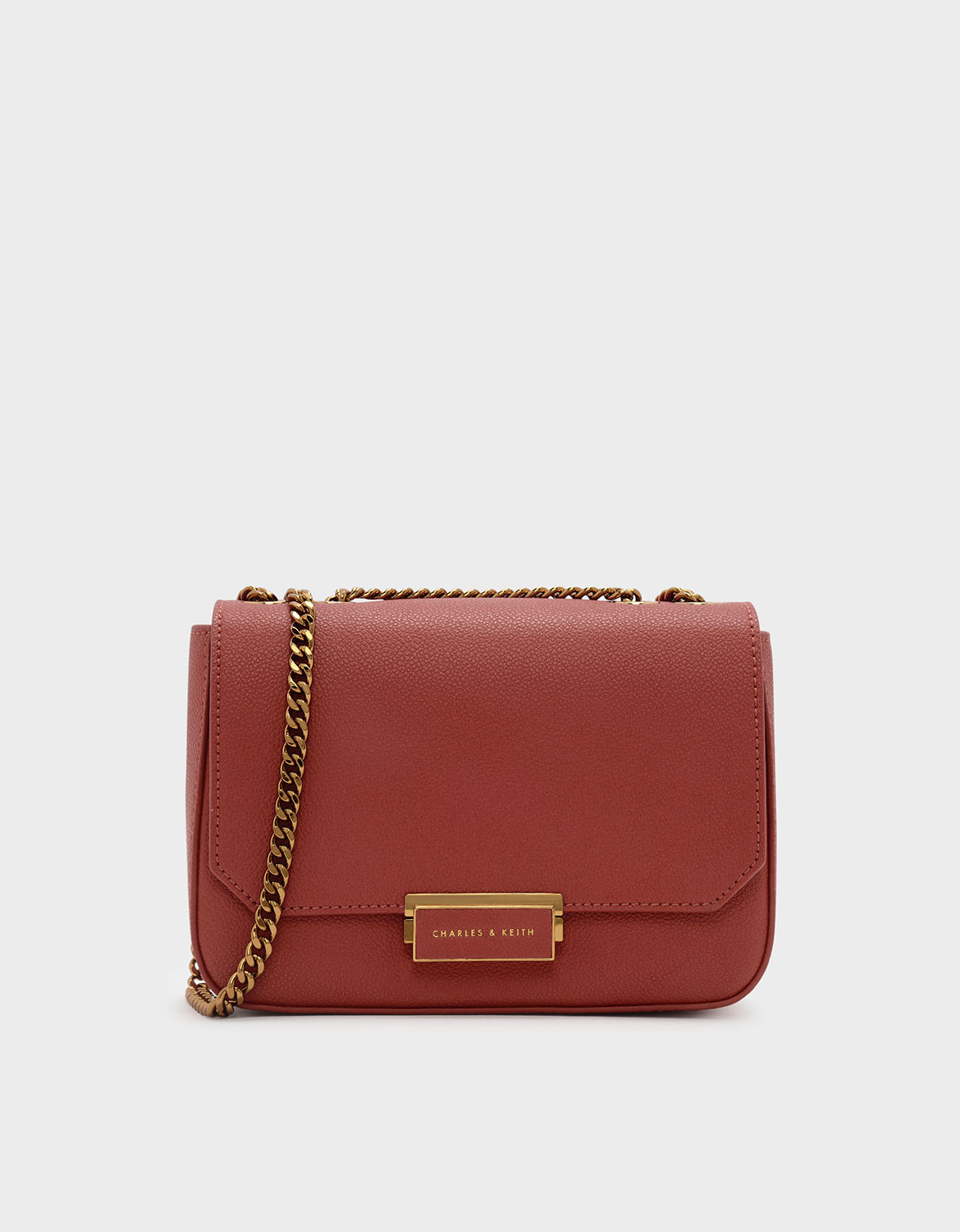 磚紅色小型經典旋扣式鍊條斜背包。