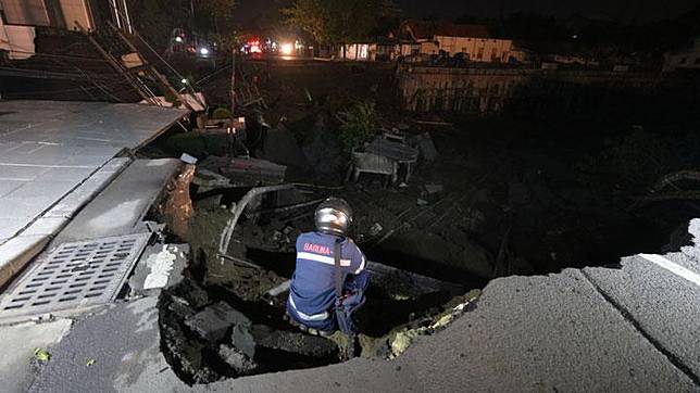 Petugas memeriksa tanah amblas di Kawasan Gubeng Surabaya, Jawa Timur, Selasa, 18 Desember 2018. Petugas masih mencari kemungkinan adanya korban di lokasi jalan amblas yang diduga karena pembangunan gedung di kawasan tersebut. ANTARA  