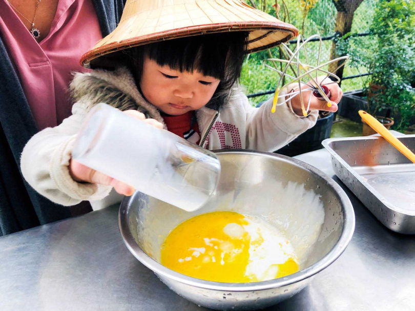 小朋友在大人的陪伴下，親手製作雞蛋糕。（圖／遠足生態農場提供）