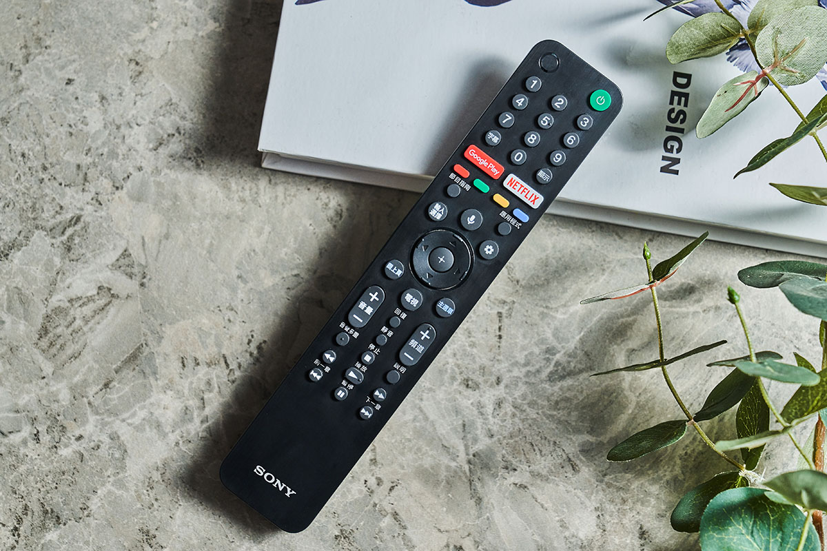 遙控器延續 Sony BRAVIA 一貫的細長型設計，四個邊角都以弧形作修飾，表面的髮絲紋處理也增添了不少質感，再加上分區邏輯明確的功能鍵配置，讓用戶可以更快、更無痛上手各種功能的操控，更棒的是遙控器上還直接內建了時下最熱門的 Google Play 以及 NETFLIX 快捷鍵，讓你能夠更直覺地進入應用程式市集擴充相關軟體，或開啟線上影音平台。