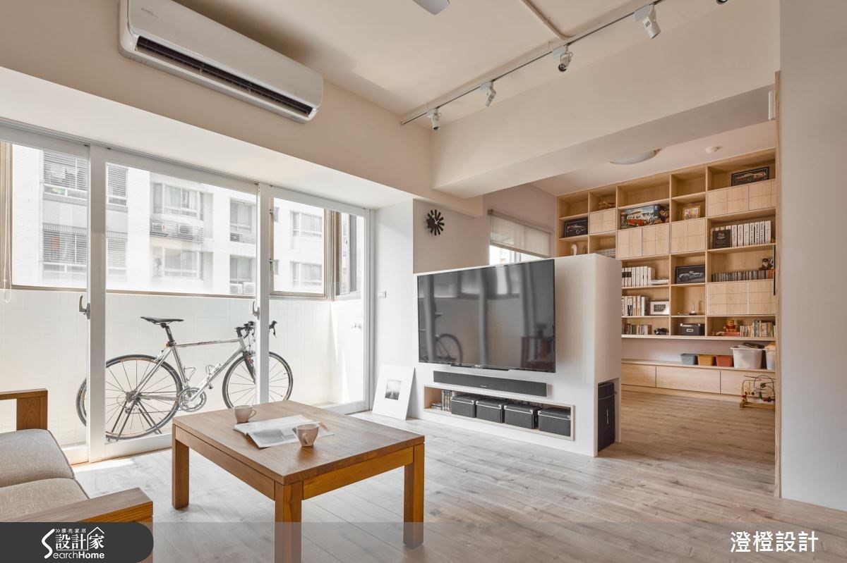 位於客廳區域的牆面式收納，上層擺放大人的讀物和收藏，下排則留給孩子們堆放玩具的專屬區域