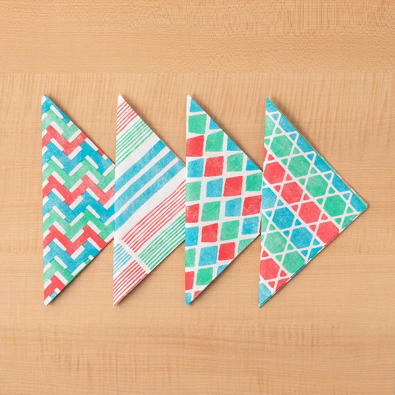 來好以復古的茄芷提袋作為概念發想，延續經典的紅藍綠三配色，運用圖騰加入白色調點綴，將形狀、線條重新排列組合成變化出不同的幾何圖形，多樣化的茄芷餐巾紙妝點在樸素的桌面上，是野餐、聚會的小巧思，當成擺拍道