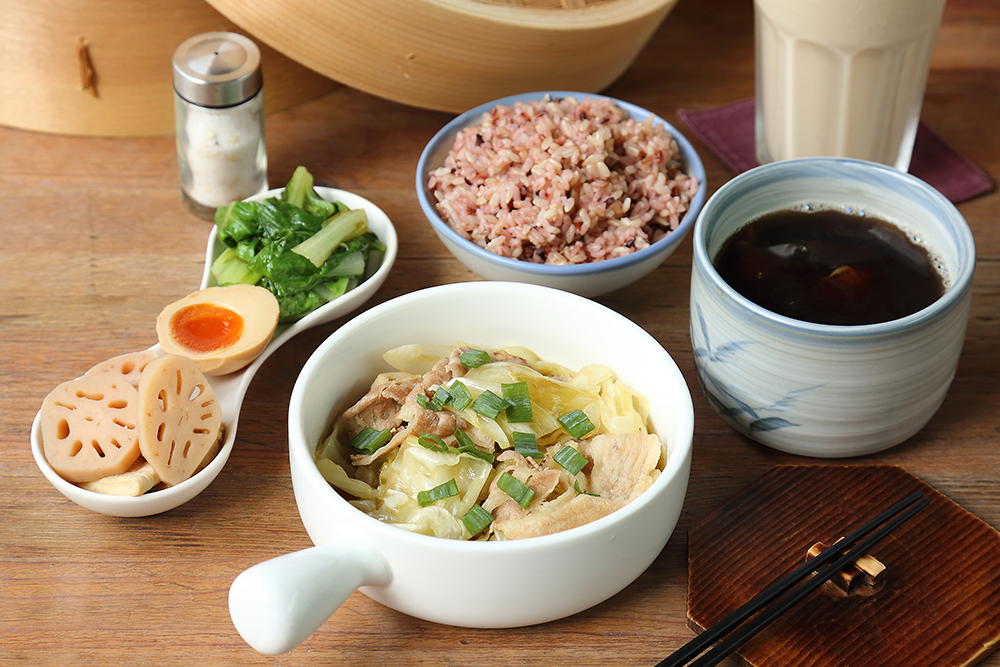 馨窩良行的家常定食包含小菜、自製溏心蛋和養生藥膳湯。主菜熱炒酸菜豬五花選用「醃菜・余記」的酸高麗菜搭配「仁允牧場」的安心豬，酸香溫和不刺激。(攝影/Carter)