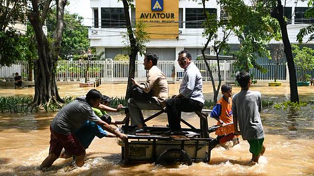 Dua orang warga menaiki gerobak yang didorong sejumlah anak saat melintasi genangan banjir di kawasan Jalan Bungur Besar Raya, Jakarta, Kamis 2 Januari 2020. Berdasarkan data Badan Nasional Penanggulangan Bencana (BNPB) per 2 Januari 2020, terdapat 63 titik banjir di wilayah DKI Jakarta dan secara keseluruhan terdapat 169 titik banjir untuk Jabodetabek dan Banten. ANTARA FOTO/M Risyal Hidayat