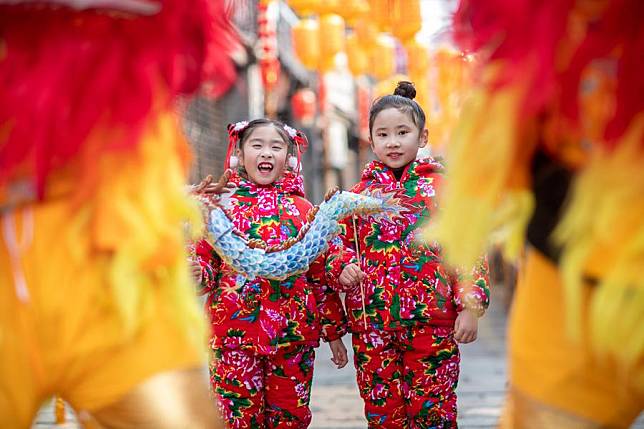 Children watch lion dance performance in Xinghua of east China's Jiangsu Province, Feb. 8, 2024. (Photo by Zhou Shegen/Xinhua)