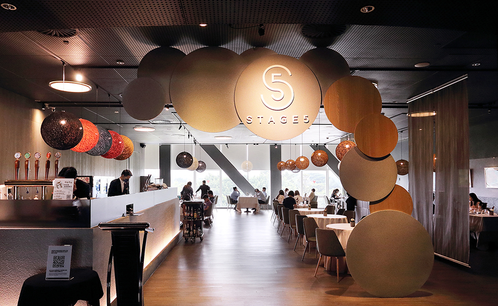 Stage 5的用餐空間簡潔時尚，落地窗外廣闊的衛武營公園帶來愉悅的用餐感受，兼具藝廊的質感與餐酒館的休閒自在。(攝影/Carter)