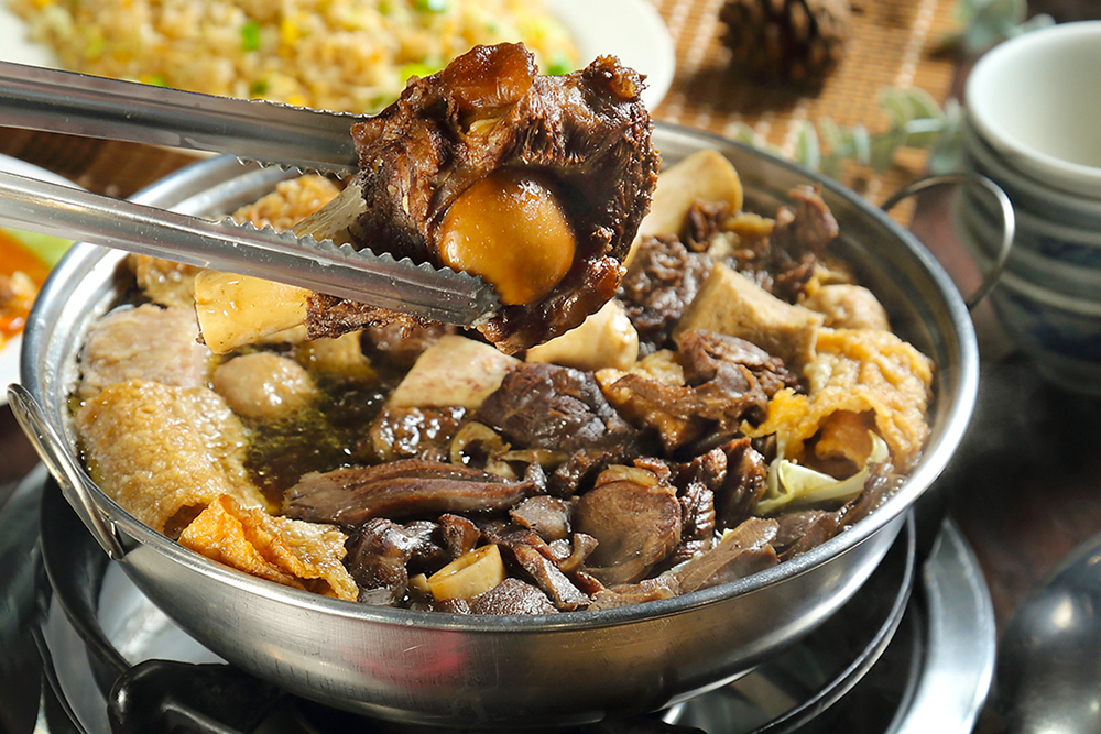 加入甘蔗熬煮的湯頭是羊肉爐的靈魂，滋補暖身、醇香甘甜，隨鍋贈送的羊大骨已成為店家特色。(攝影/Carter)