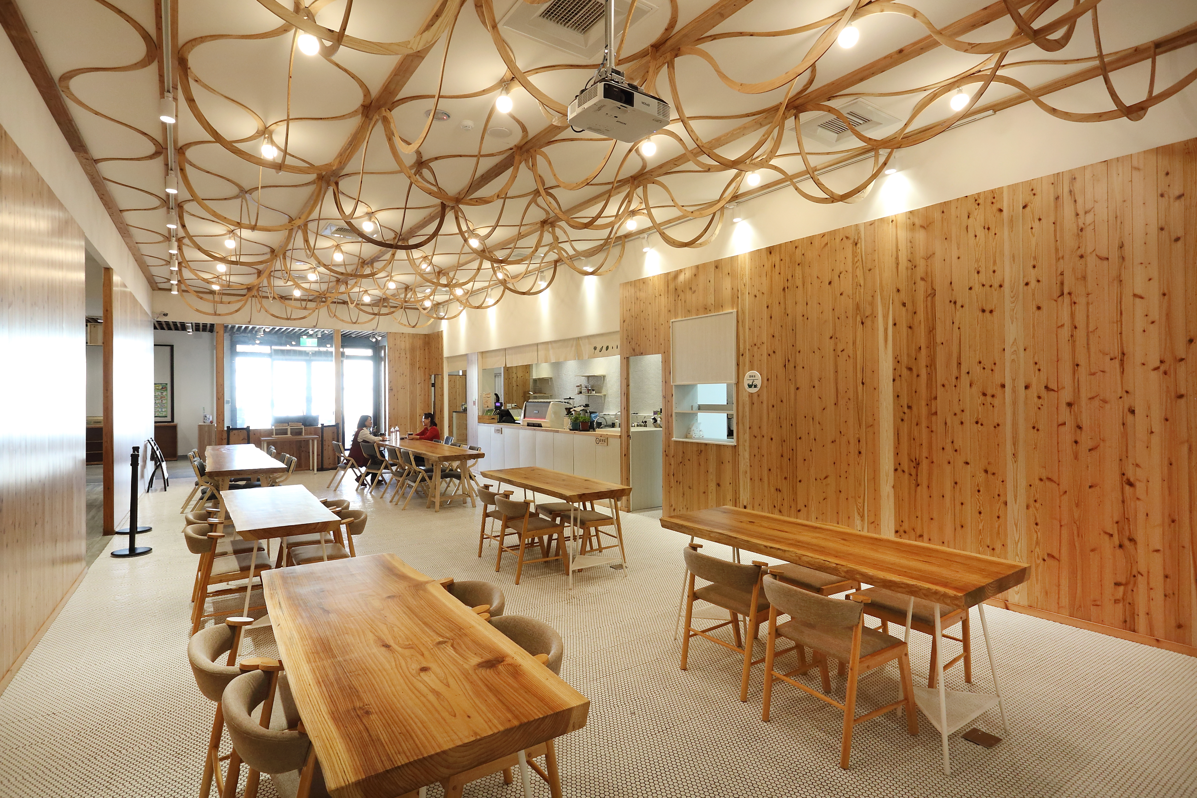 「未來超市」天花板的杉木飾板相當吸睛，以客家編織技藝詮釋「斗笠」，從側面看則是「果實」的意象。(攝影/Carter)