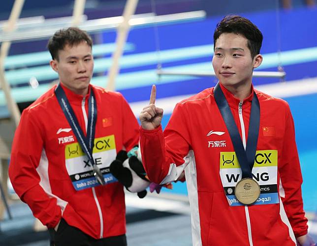 Wang Zongyuan ® and Xie Siyi of China react after the awarding ceremony for the men's 3m springboard of diving at the World Aquatics Championships 2024 in Doha, Qatar, Feb. 7, 2024. (Xinhua/Luo Yuan)