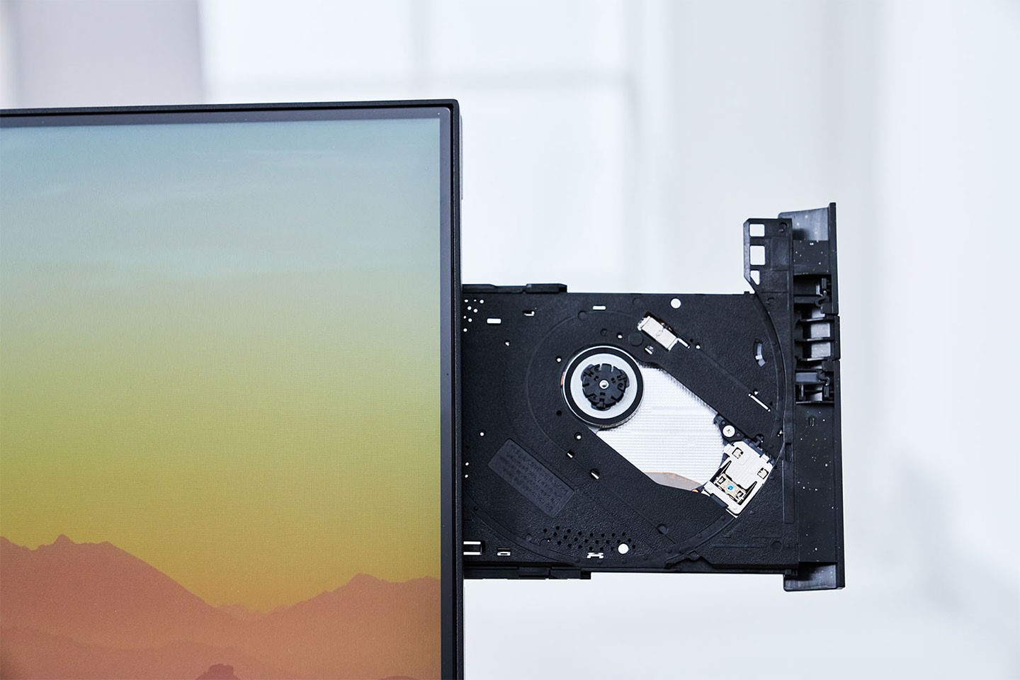 按下按鈕後托盤會彈出，這組 DVD 燒錄機為筆電用模式，軸心處能固定住碟片，放置時不必擔心垂直角度會讓碟片掉落。