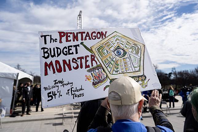 A protester holding a placard saying U.S. war machine: real threat to  peace at a rally against war with Russia sponsored by multiple groups  including CODEPINK: Women for Peace, Black Alliance for