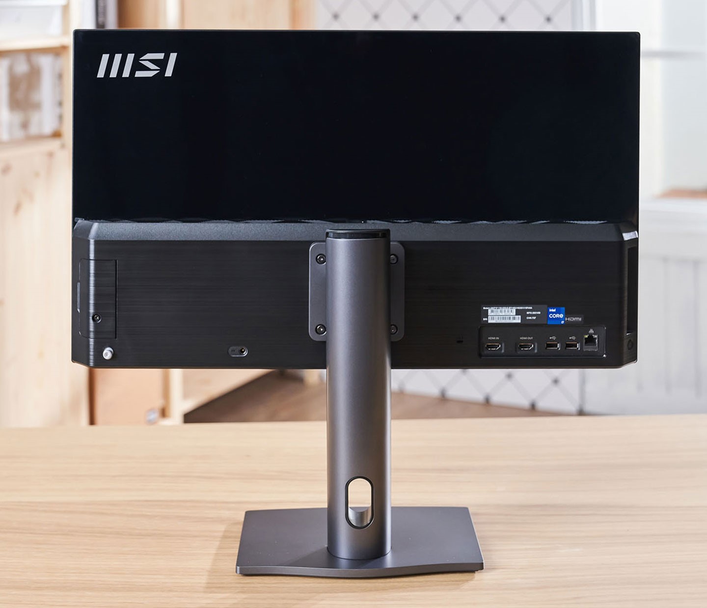 機身後側採雙材質拼接設計，上半部為亮面鋼琴烤漆，下半部則為細膩的髮絲紋路，這樣的手法也成功在簡約風格中加入了些許變化。另外，顯示器支架與底座皆為深灰色金屬材質，可以穩穩地撐住 27 吋的大螢幕。