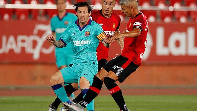 Aksi pemain Barcelona, Lionel Messi saat berebut bola dengan pemain Mallorca, Salva Sevilla dalam laga lanjutan Liga Spanyol di Stadion Iberostar, Palma, Spanyol, 13 Juni 2020. REUTERS/Albert Gea