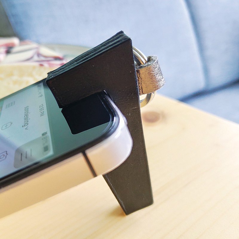 設計師一直不喜歡把外置配件用在手機上，但又愛用手機看電影，所以在家時會把手機放在迷你的架子上，但因為太不時尚，所以想用皮革設計一個既時尚又實用的手機座。