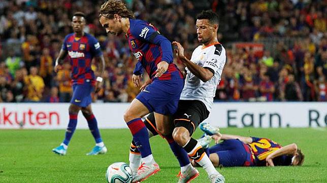 Pemain Barcelona, Antoine Griezmann berebut bola dengan pemain Valencia, Francis Coquelin dalam laga pekan keempat Liga Spanyol di Stadion Nou Camp, Spanyol, 14 September 2019. REUTERS/Albert Gea  