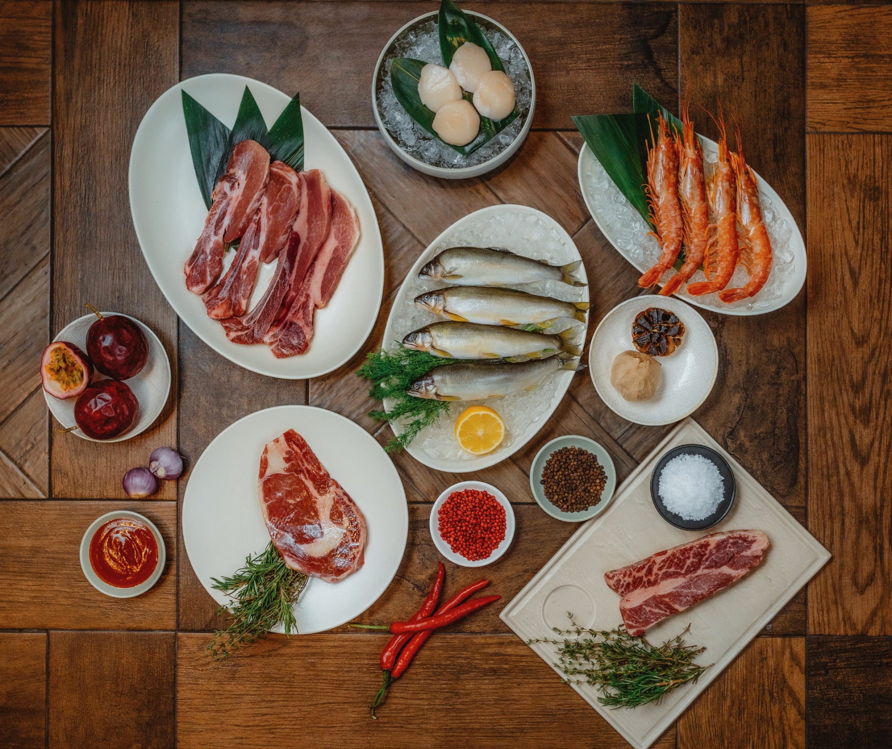 WILDWOOD原木燒烤牛排海鮮餐廳推出『米其林星廚烤肉組』（2980元/組），精選海陸高檔食材搭配主廚特製百香果風味烤肉醬及天然發酵黑蒜，為闔家團圓增添豐足美味，9/3前訂購且無指定到貨日期者，享免費配送服務。(圖片提供/WILDWOOD)