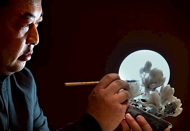 Liu Xiaoqiang conceives his next moves on an unfinished work at his studio in Zhenping County of Nanyang City, central China's Henan Province, Jan. 23, 2024. (Xinhua/Li An)