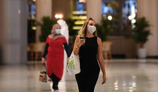 Biasakan pakai masker ketika pergi ke mal di tengah pandemi corona. (Foto: AFP)