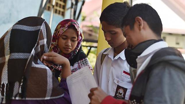 Siswa mendata rekannya saat hari pertama masuk sekolah di SMA PGRI, Palu, Sulawesi Tengah, Senin (8/10). [ANTARA FOTO/Wahyu Putro] 