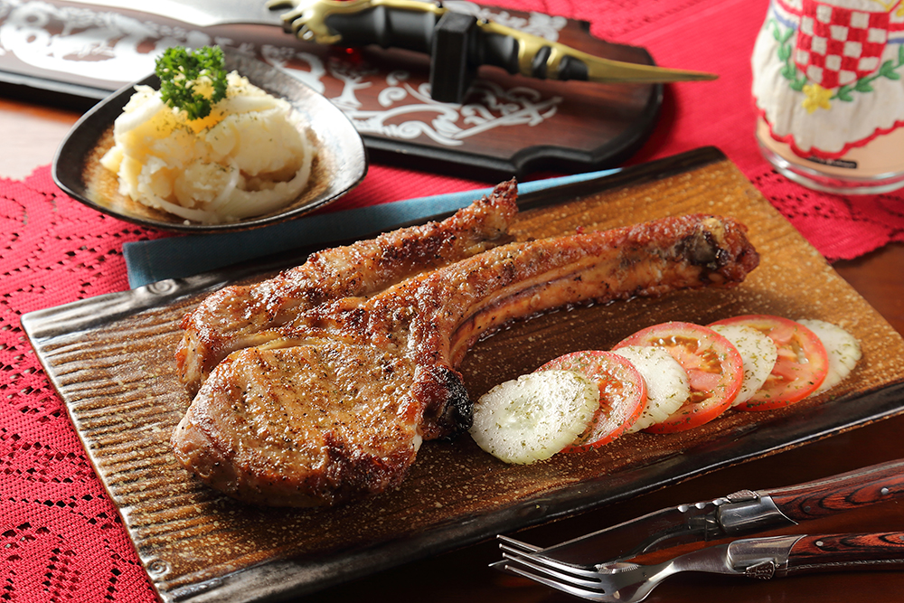 「克國戰斧豬」取用豬的第4、5根肋骨部位，以克羅埃西亞的天然辛香料醃製，並經直火慢烤，肉汁飽滿不乾柴，搭配清爽微酸的馬鈴薯沙拉更加分。(攝影/Carter)