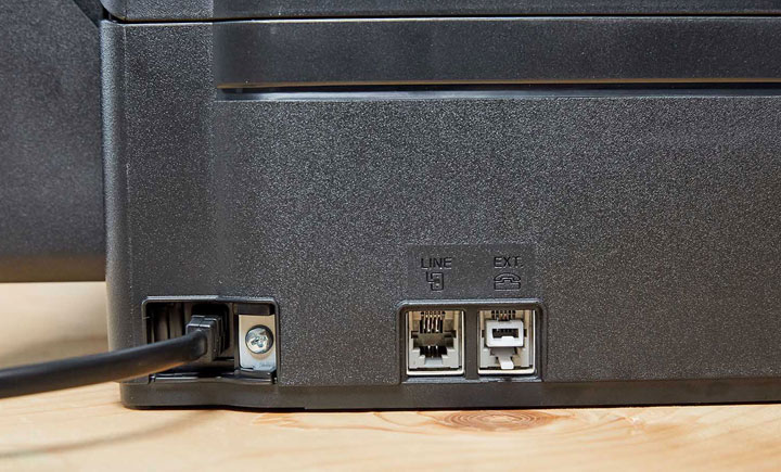 機身側面可看到電源線與預留的傳真線路（Line IN、Line Out 各一組）。