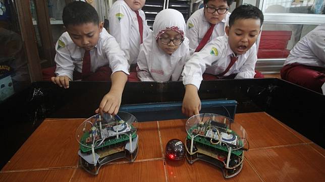 Pelajar SD Muhammadiyah 4 Surabaya memperagakan robot Green Force di Surabaya, Jawa Timur, Senin (30/4). Mereka berhasil meraih medali emas di ajang RoboCup Singapore Open 2018 untuk kategori robot soccer. [Antara/Moch Asim]