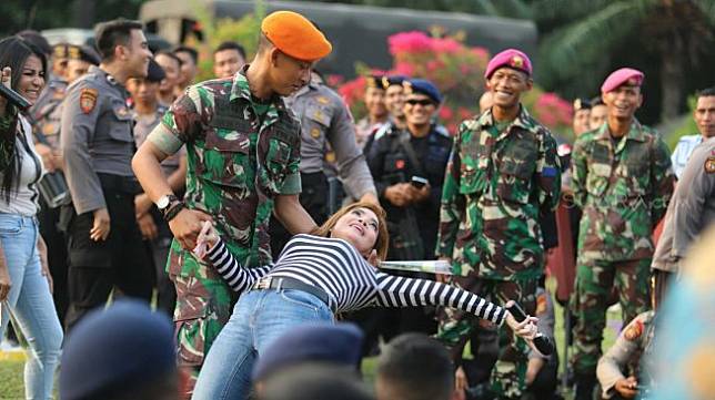 Penyanyi dangdut Irma Darmawangsa menghibur anggota TNI-Polri di halaman Gedung DPR RI, Jakarta, Jumat (18/10). [Suara.com/Arya Manggala]
