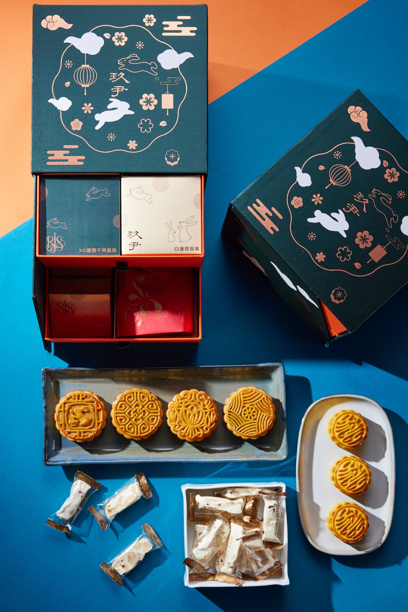 時尚中餐廳《玖尹》今年中秋推出「墨月臻品雙層禮盒」，墨綠絲質環保布質感外盒，雙層抽屜內含XO醬干貝蛋黃、白蓮蓉蛋黃、棗泥核桃、香橙鐵觀音四顆廣式月餅，奶黃流心迷你小月餅三入、以及台北老爺酒店人氣伴手禮手工牛軋糖一袋15入。(圖片提供/玖尹)