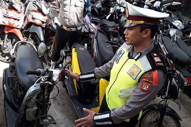 Kasat Lantas Polres Tangsel AKP Lalu Hedwin memperlihatkan motor milik Adi yang dirusak lantaran tidak mau ditilang.Foto/SINDOnews/Hasan Kurniawan