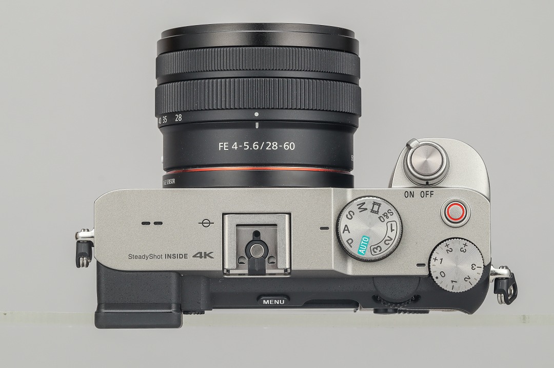 機頂配置與 A73 系列講求操作感的概念不同，A7C 在設計方面力求簡潔，機頂配置亦相對單純，捨棄了前滾輪與 C1、C2 自訂鍵，同時將錄影鍵移至機頂，讓 A7C 具備有近似於旁軸相機的風格。