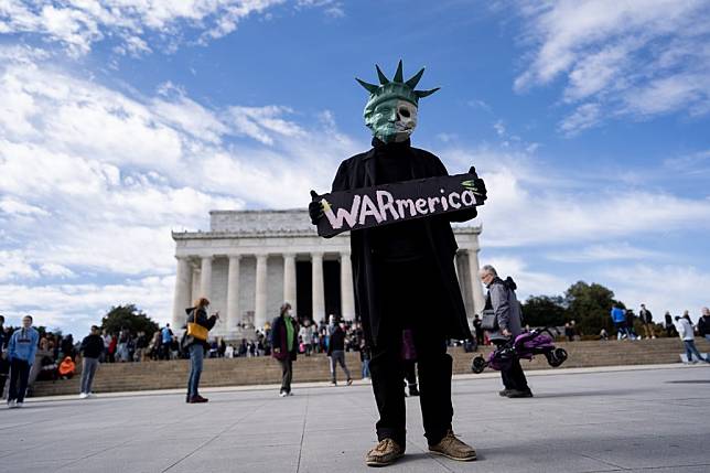 A protester holding a placard saying U.S. war machine: real threat to  peace at a rally against war with Russia sponsored by multiple groups  including CODEPINK: Women for Peace, Black Alliance for