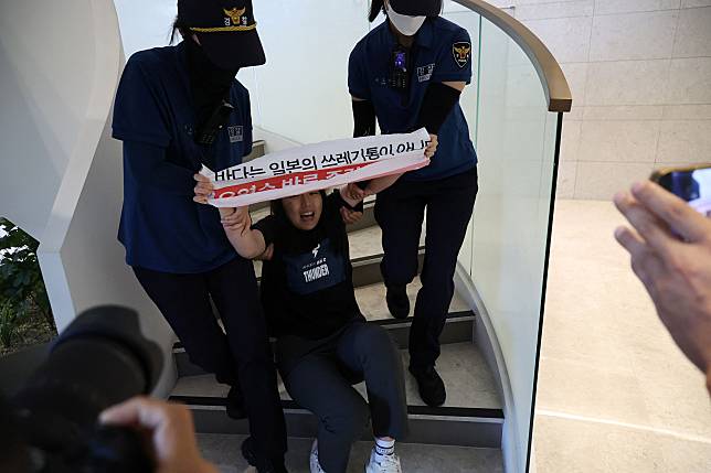 大學生們組團到大使館抗議日本排放核廢水，遭警方強制驅離。（路透社）