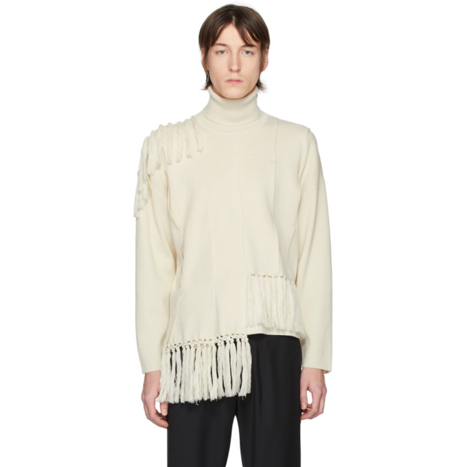 Long sleeve panelled rib knit wool and cotton-blend sweater in off-white. Asymmetric tassel-style tr