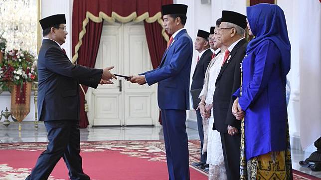 Presiden Joko Widodo menyerahkan petikan keputusan kepada calon Menteri Pertahanan Prabowo Subianto (kiri) dalam rangkaian acara pelantikan menteri Kabinet Indonesia Maju di Istana Merdeka, Jakarta, Rabu (23/10). [ANTARA FOTO/Puspa Perwitasari]