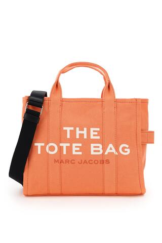 The Small Traveler Tote bag by Marc Jacobs in cotton canvas, featuring adjustable and removable webbing strap, front logo print, back logo patch, zip closure, side handle. Unlined interior with one zip pocket and two small pockets. Steel-finish metalware.